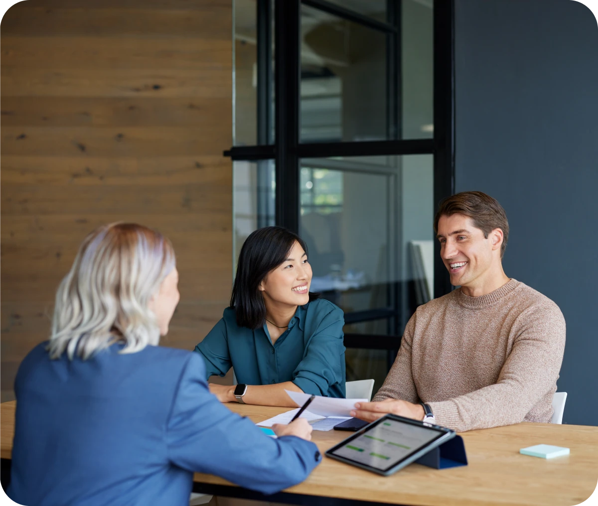 Business meeting with three people smiling